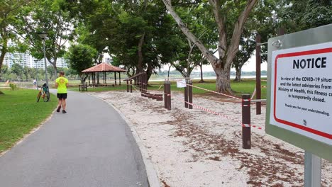 workout static stations with barrier tape and warning sign during covid-19 lockdown in a public park in singapore, asia
