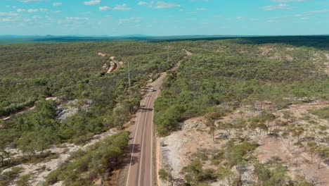 aerial shot following a bus travelling along highway at outback queensland