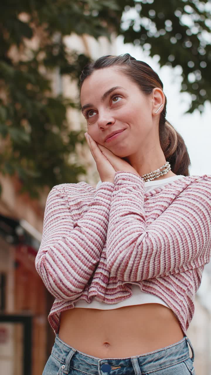 Thoughtful smiling happy young woman with pensive expression pondering a solution dreaming thinking