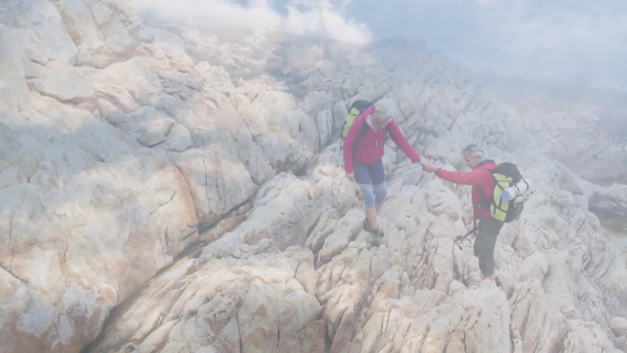 Couple hiking rugged coastal cliff, displaying animated heart icon and health chart overlay