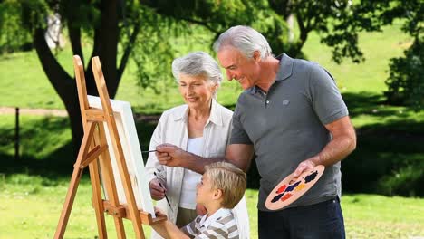 Young-boy-and-grandparents-painting-a-canvas