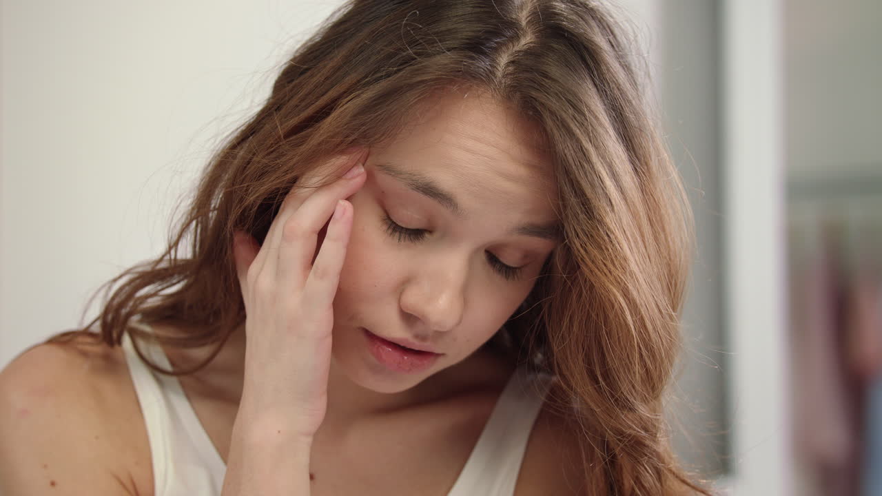 dolor de cabeza de una mujer joven. primer plano del rostro de una mujer sintiendo dolor en la cabeza