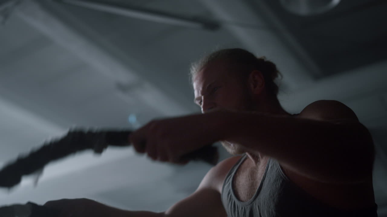 로프와 싸우는 보디빌더. 로프와 싸우는 운동 중에 비명을 지르는 스포츠맨