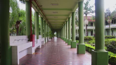 long college hallway with multiple green columns