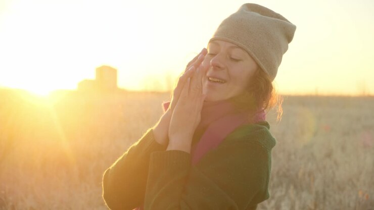 Woman enjoying a beautiful sunrise in a field