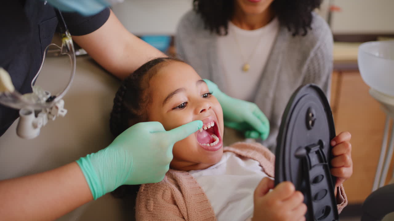 Dentist examining little girls teeth