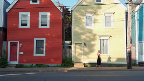 colourful homes with woman walking in front of in the morning in halifax, nova scotia