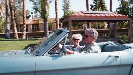 Senior-white-couple-on-the-road-in-a-classic-convertible-car