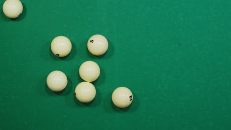 breaking white pool balls top view on green billiards table for start to play. russian biliard game, russian pyramid. billiard balls with numbers on a pool table. billiards team sport. high quality 4k footage