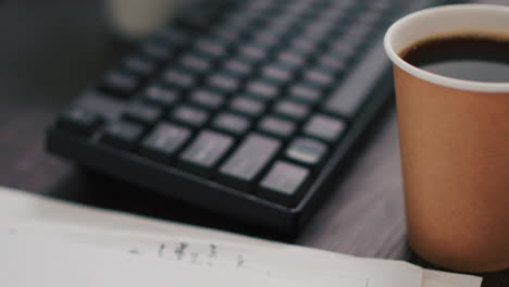 business paperwork on office desk next to cup of coffee, extreme close up shot