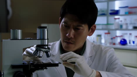 a man working with a microscope in a laboratory