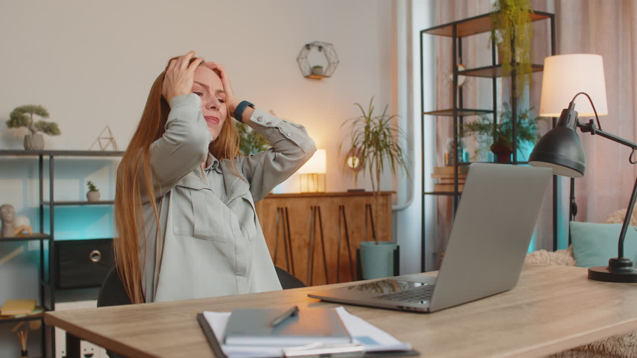 расстроенная недовольная женщина фрилансер с помощью ноутбука читает плохие новости сидит за столом в гостиной