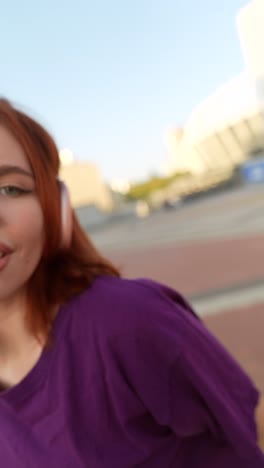 woman in purple shirt and blue jeans outside a building