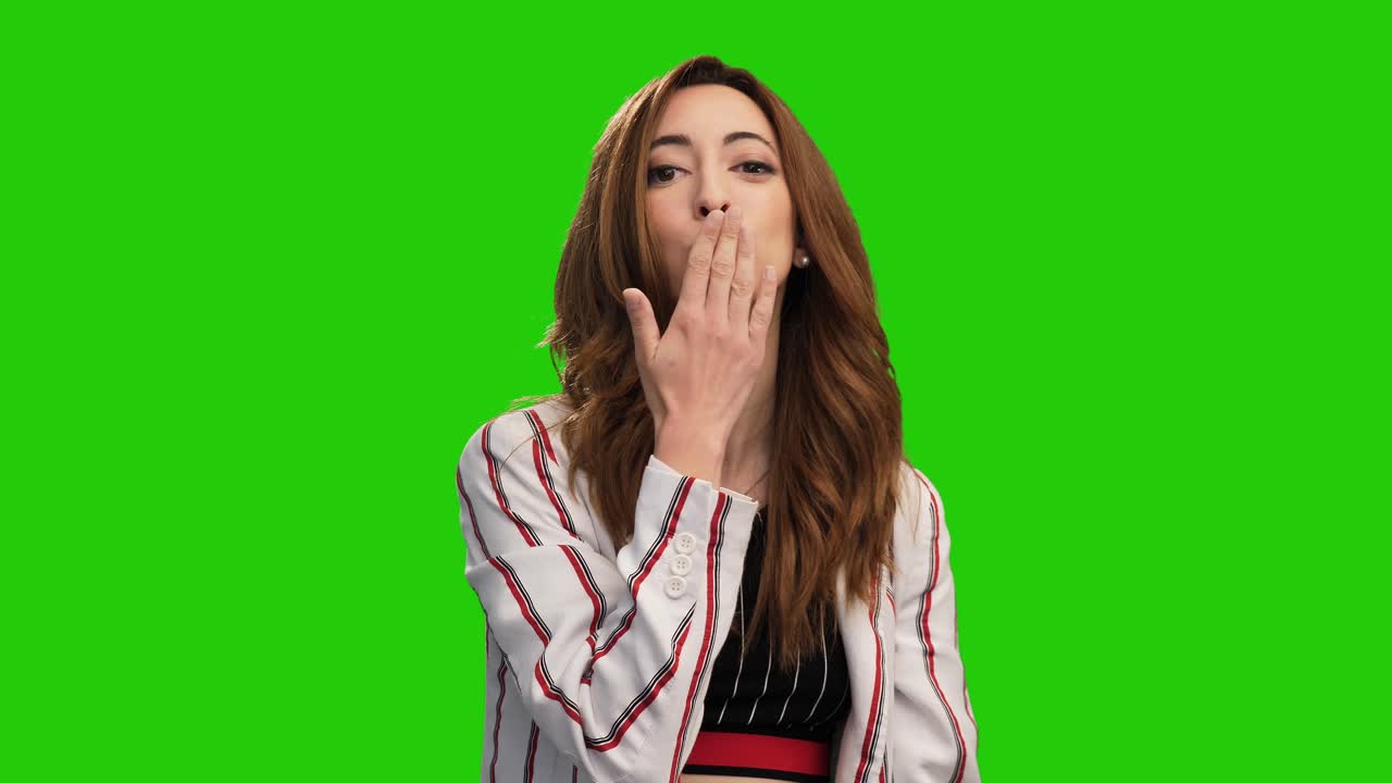 retrato de una linda mujer caucásica hace un gesto de corazón con las manos y sopla un beso en la pantalla verde