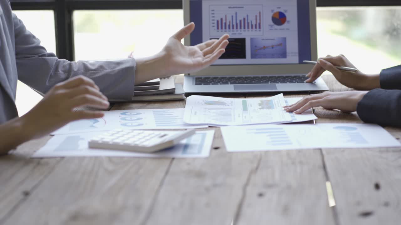 Investment advisor 2 business people analyze company financial statements working with document graphs for stock market, office, tax and project team of data analysts working with tablet computers.