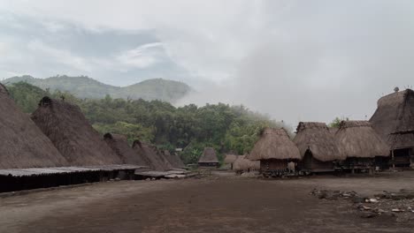 traditional village with thatched roof houses in a foggy mountain landscape