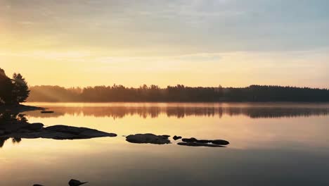 pan of golden hour sunrise over lake, hällingsjö, sweden