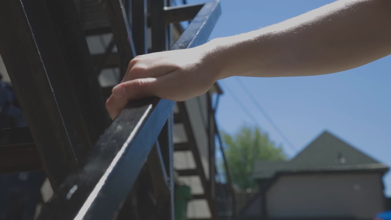 A Man's Hand On The Steel Railing While Walking Down The Stair Outdoor - close up slowmo