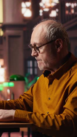 vertical video elderly man highlighting important ideas from coursework papers