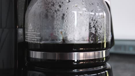 close up shot of a coffee makers brewing black coffee