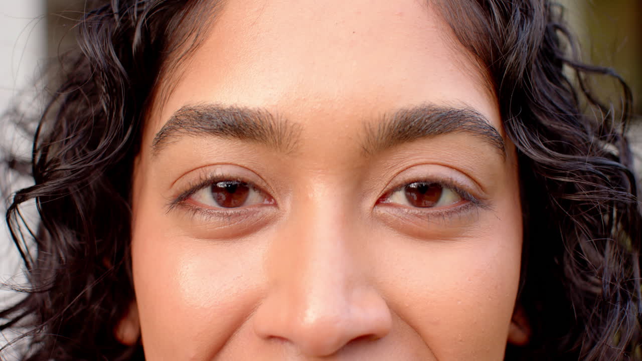 Smiling person with curly hair enjoying time with friends outdoors