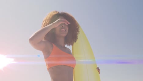 animación de luces sobre una mujer afroamericana que sostiene una tabla de surf