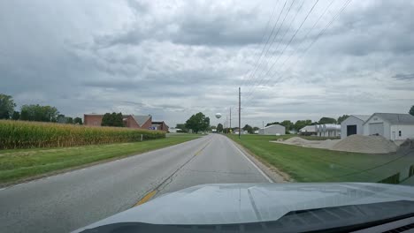 pov - driving into a small midwest town on a cloudy day in late summer