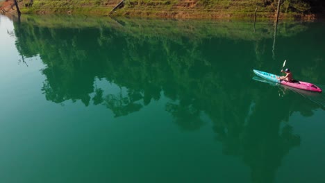 Mann,-Der-An-Einem-Sonnigen-Tag-Auf-Dem-Ruhigen-See-Mit-Reflexionen-Im-Khao-Sok-Nationalpark-In-Thailand-Kanu-Fährt