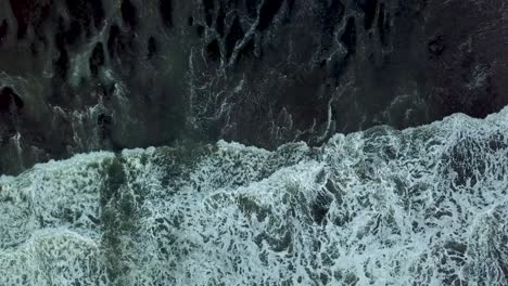 birds eye view of abstract ocean splash on bali beach near tanahlot temple, indonesia - aerial top view