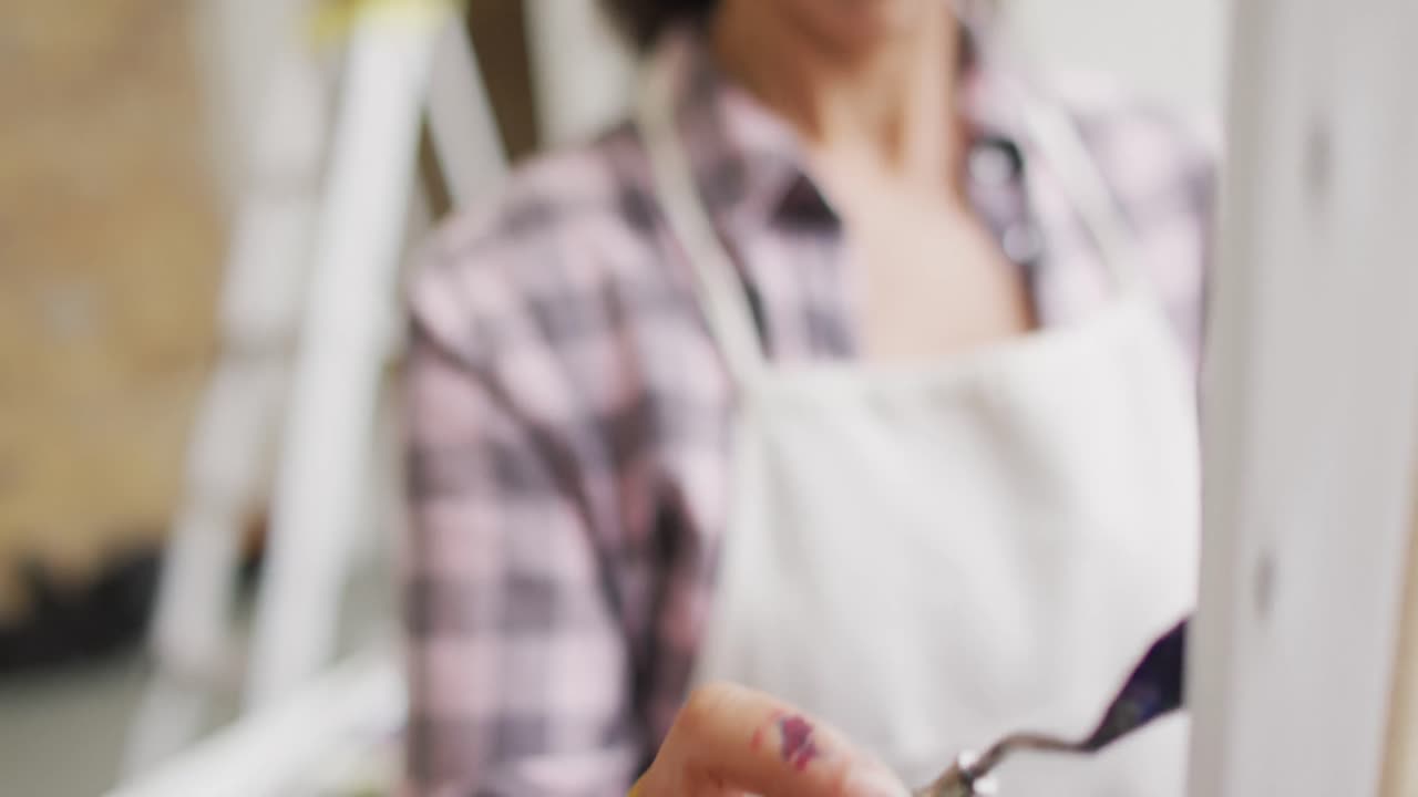 video delle mani di un'artista bieraziale che dipinge in studio