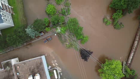 flooded urban shopping centre with cars submerged underwater in parking lot after natural disaster