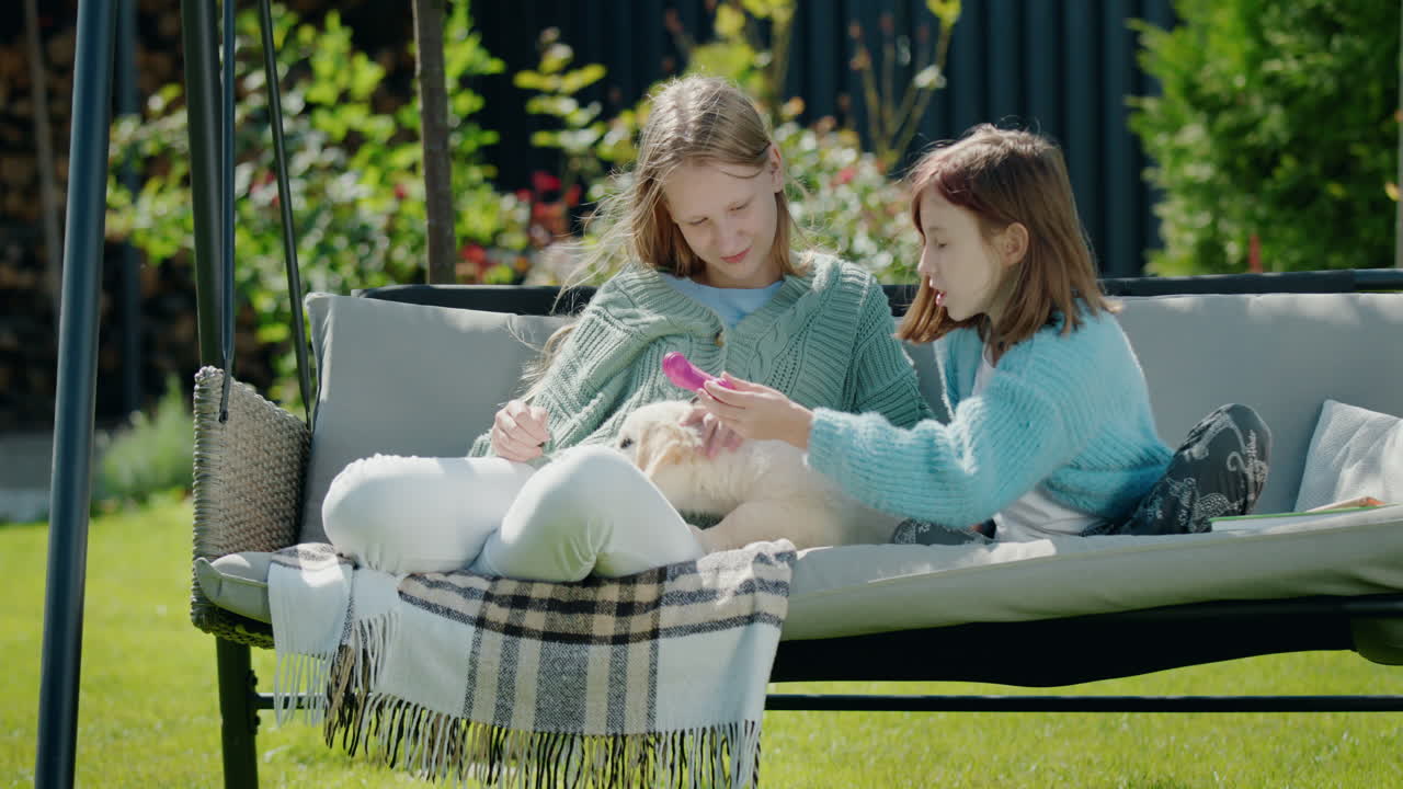두 아이가 집 뒷마당의 정원에서 휴식을 취하고, 귀여운 강아지와 놀고, 정원 스에 앉아 있습니다.