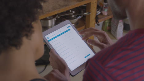 young couple using tablet computer, over shoulder view, shot on r3d