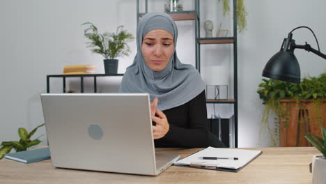 Muslim-business-woman-thinking-about-an-important-creative-project-work-decision-on-laptop-at-office