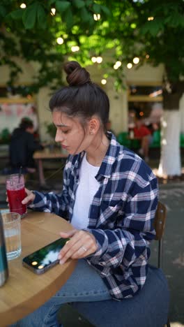 woman drinking juice at outdoor cafe