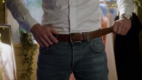 Man-puts-his-belt-on