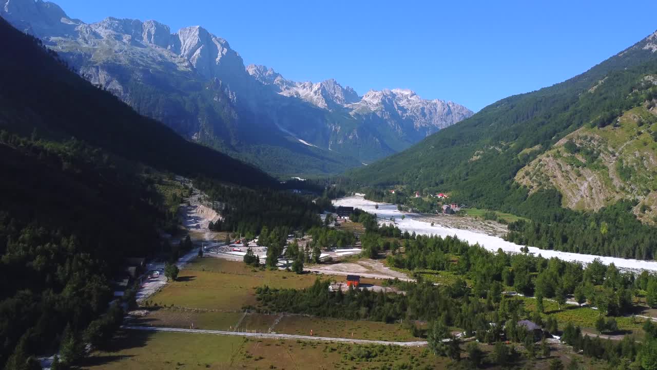 Paesaggio panoramico di una valle montana con case e fiume