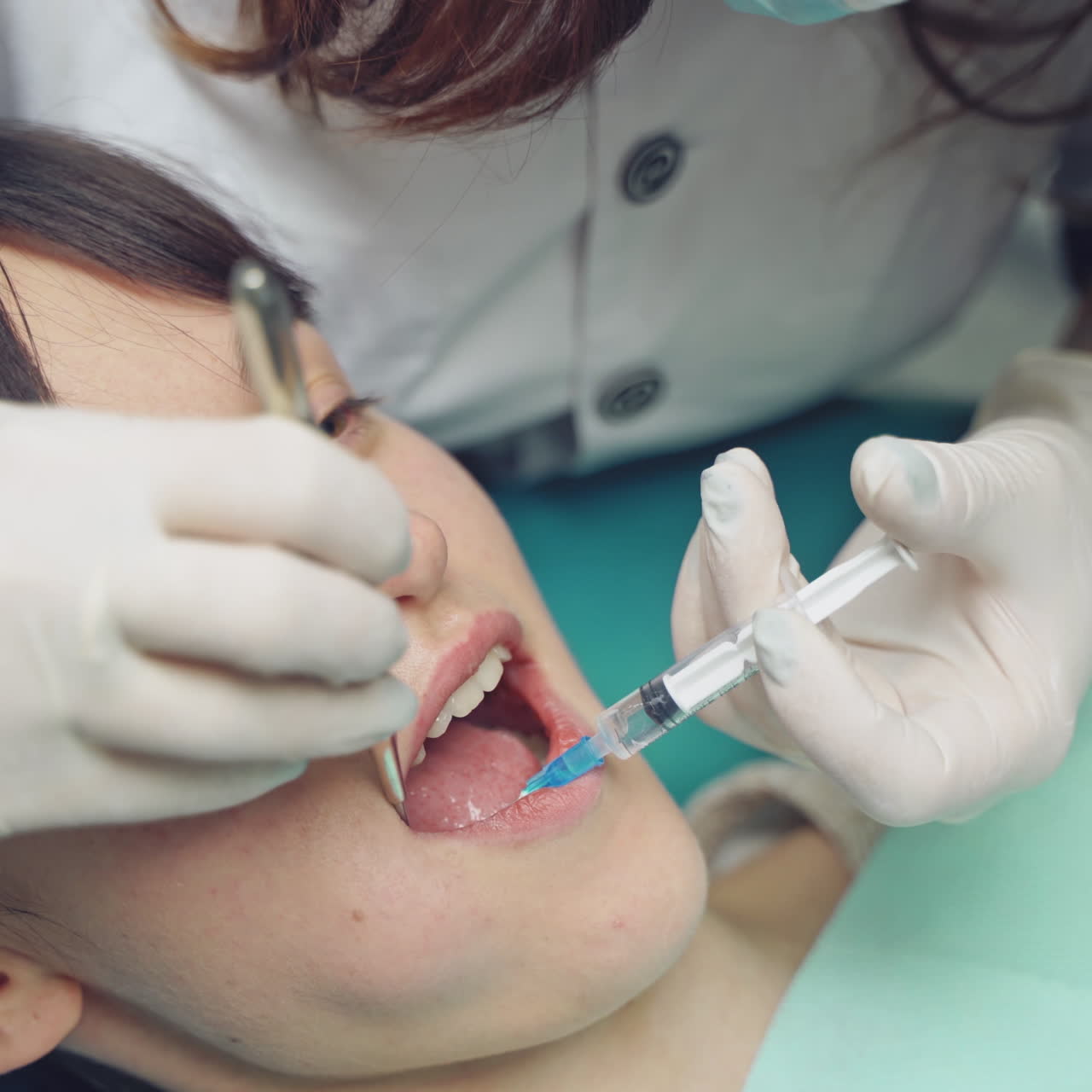 Dentist is treating a patient in a modern dental office.