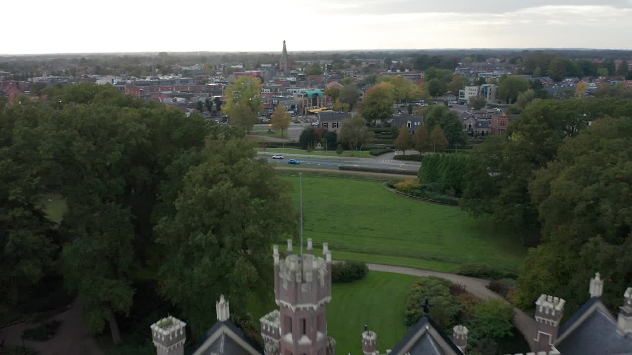 antena sobre árboles y hermosa mansión, revela una carretera muy transitada cerca de una pequeña ciudad