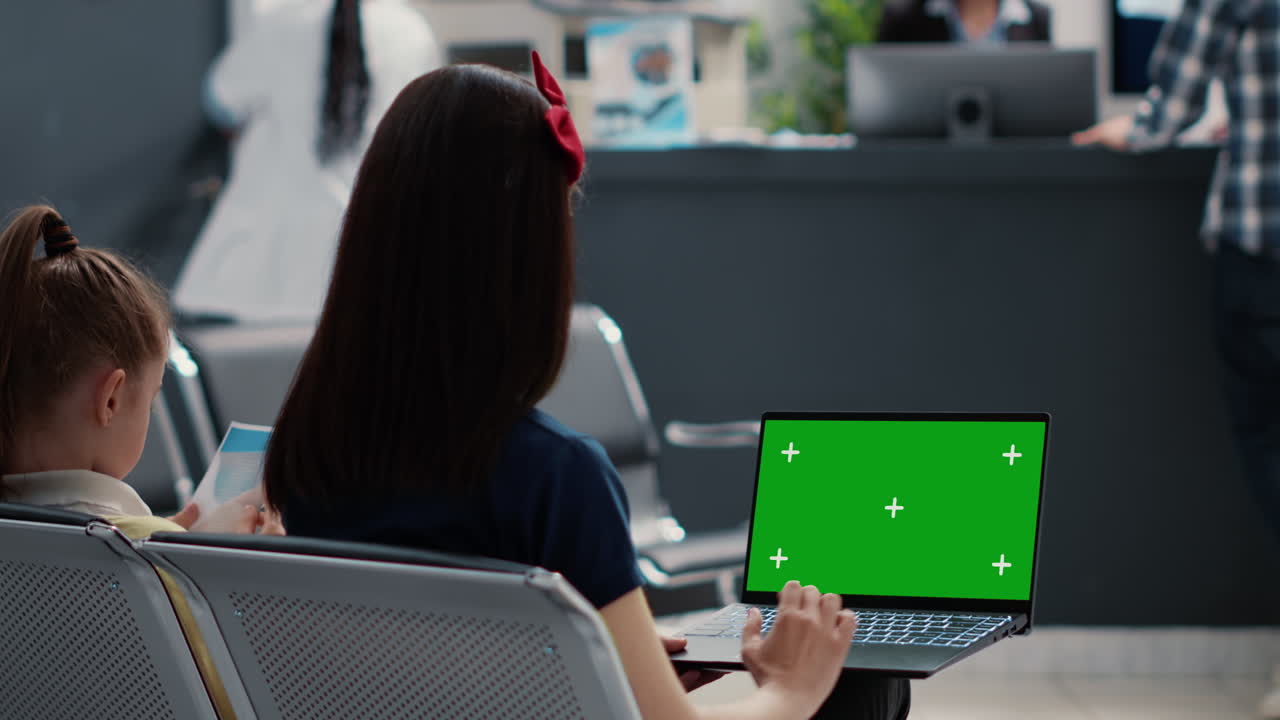 People Using Laptop with Green Screen in Hospital Waiting Room