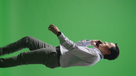 비즈니스맨이 녹색 스크린에서 전화로 이야기하고 있습니다.