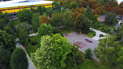wind blowing hard and shaking trees in the city park. big fountain in the city garden. aerial view.