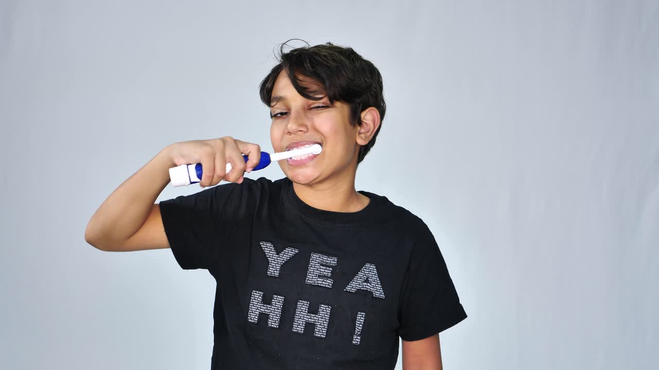 Boy using electric toothbrush to wash teeth