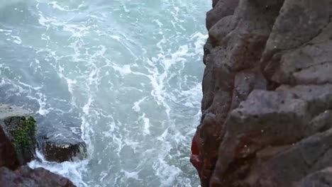 agua de mar que fluye a través de las piedras - inclínate hacia el mar