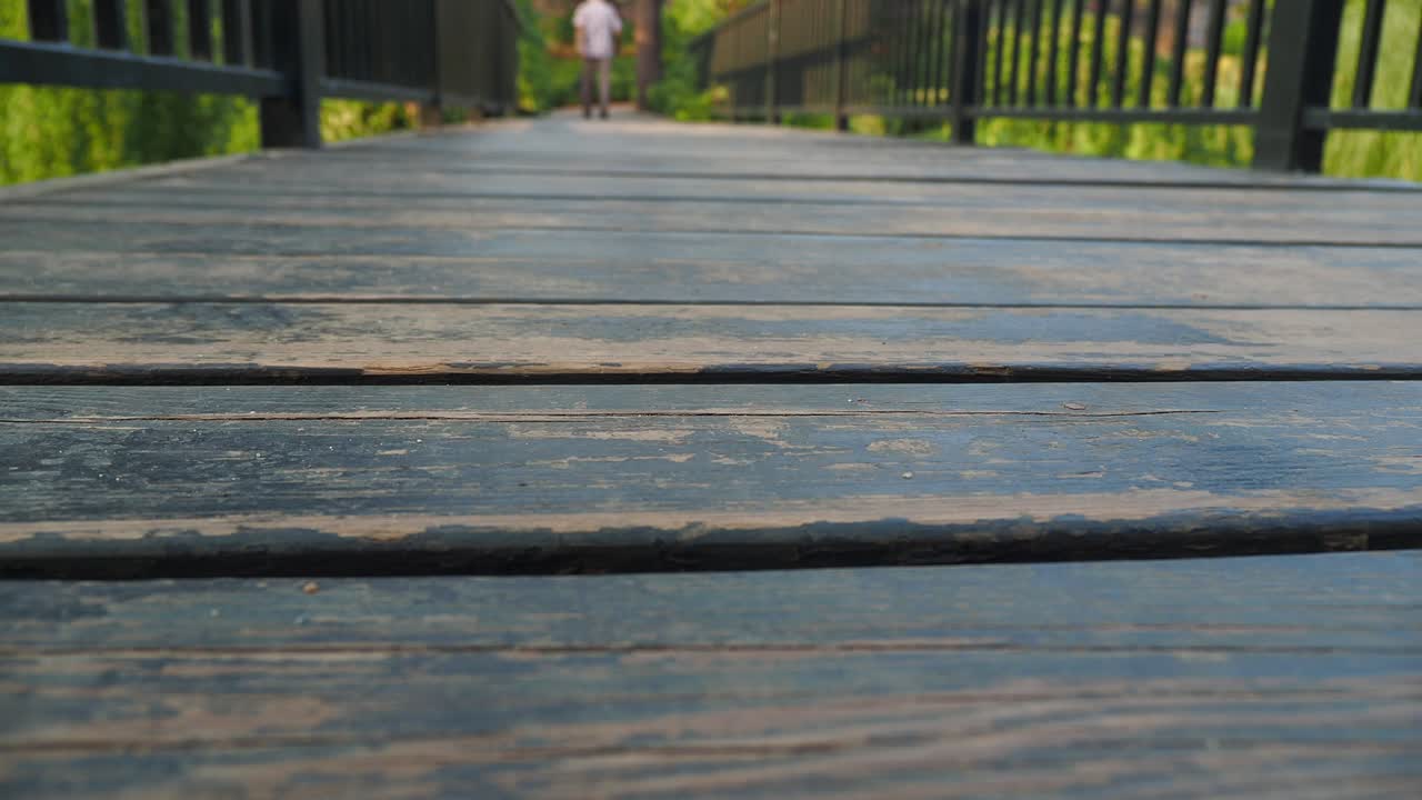 나무 다리 위 를 고 있는 사람