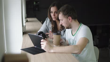 reunión de trabajo en la agencia de fotografía. cliente y fotógrafo discuten el pedido y ven los resultados del trabajo. disparado en 4k