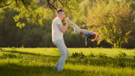 Un-Padre-Amoroso-Sonríe-Caminando-Con-El-Niño-Sentado-En-El-Cuello-Al-Atardecer-En-Un-Prado-En-Verano-En-Cámara-Lenta.