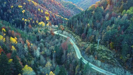 Erstaunliche-Drohnenansicht-Der-Fahrbahn-In-Bergen,-Die-Mit-üppigem-Herbstlaub-Bedeckt-Ist