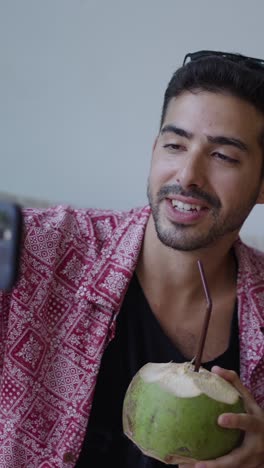 man drinking coconut beverage
