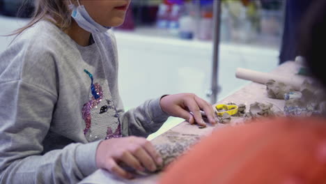 child creating art with clay